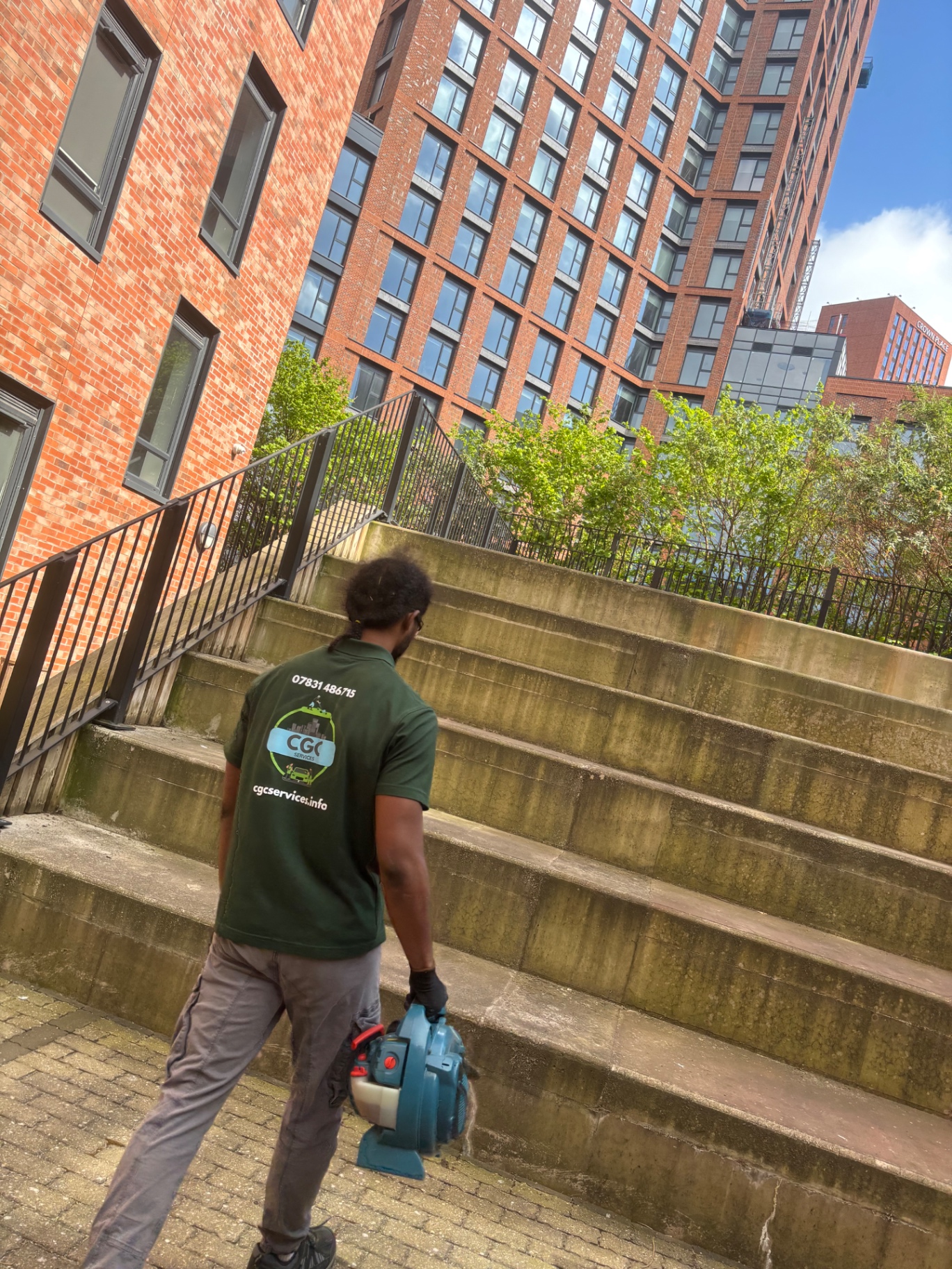 CGC Services team member clearing steps with a leaf blower